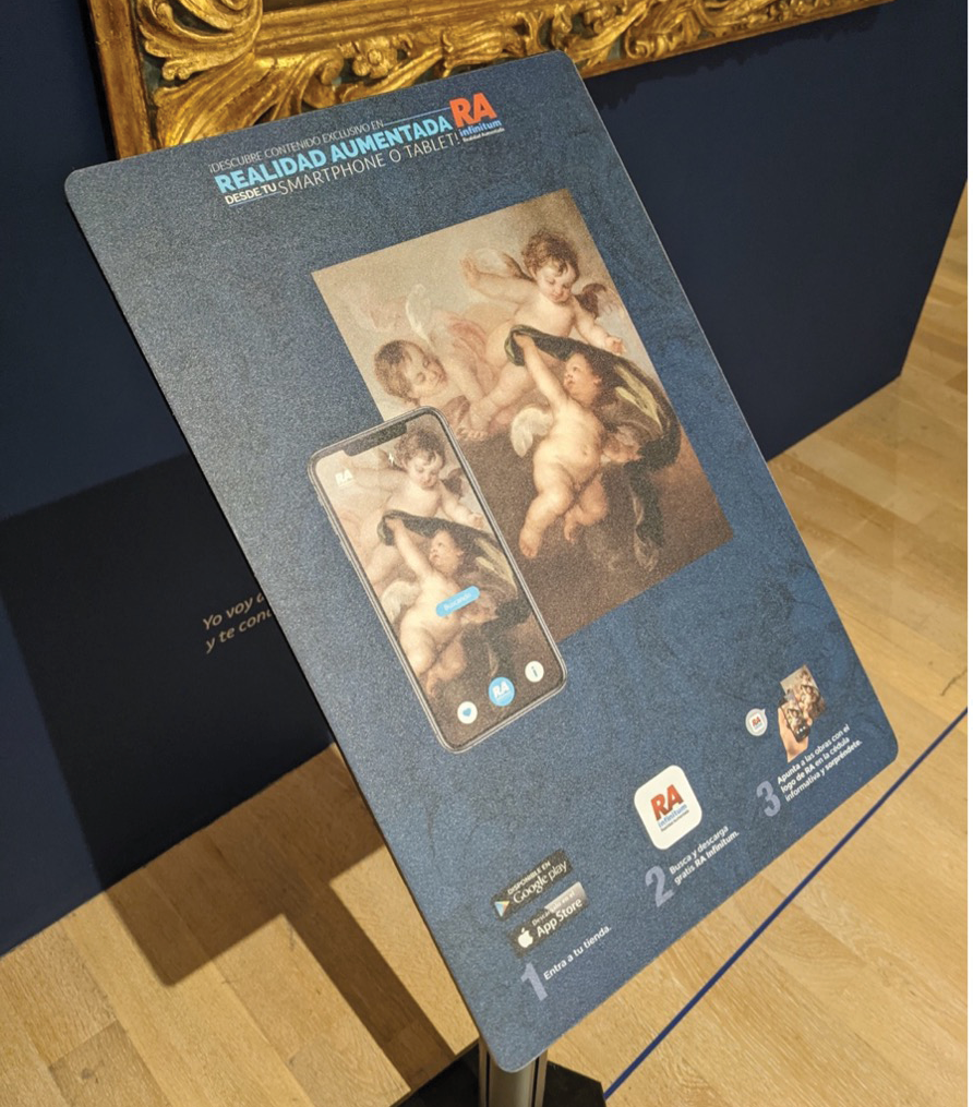 A Spanish language museum placard displaying visual instructions for using a smartphone to view AR content related to each exhibit.